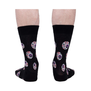 Rear view of a pair of black crew socks with an eyeball pattern.
