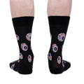 Rear view of a pair of black crew socks with an eyeball pattern.