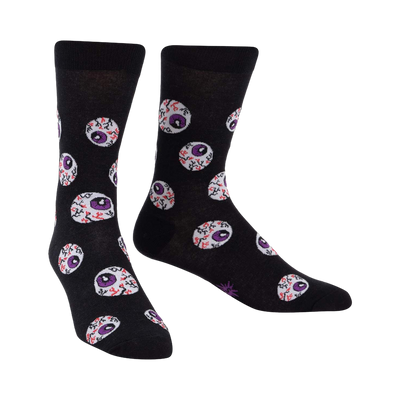Black crew socks with a repeating pattern of purple and red eyeball designs. The socks glow in the dark.