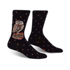 A pair of black crew socks with a red diamond pattern. A charming owl wearing a bow tie and perched on a stack of books is featured on the socks.