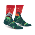 Crew socks in red and green, showcasing dinosaurs, a volcano, and palm trees.  The design glows in the dark!