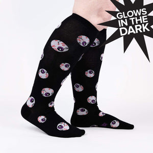 A pair of black knee-high socks with a pattern of cartoon eyeballs.