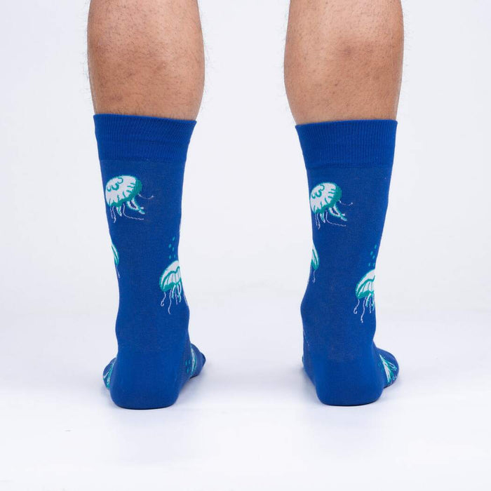 A blue sock with a white jellyfish. The jellyfish has green details.