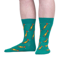 Lifestyle shot of a person wearing teal crew socks with a chicken pattern. The socks are shown from the knees down.