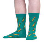 Lifestyle shot of a person wearing teal crew socks with a chicken pattern. The socks are shown from the knees down.