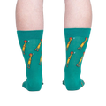 Rear view of teal crew socks with a repeating pattern of yellow chickens, showcased against a neutral gray background.