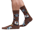 Lifestyle shot showing brown camera socks on a person's legs against a white background.