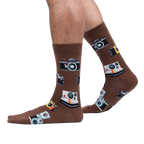 Lifestyle shot showing brown camera socks on a person's legs against a white background.