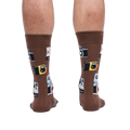 Rear view of a person wearing brown crew socks with a retro camera print.