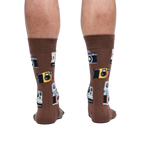 Rear view of a person wearing brown crew socks with a retro camera print.