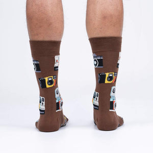 A pair of brown crew socks with a pattern of vintage cameras on them.