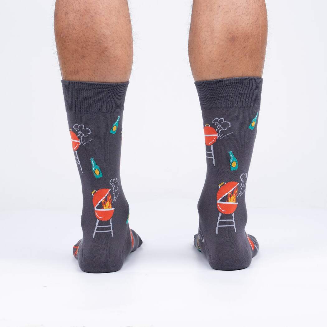 Rear view of male model wearing 'Steaks are High' socks, showcasing the design's full coverage.