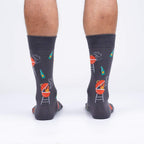 Rear view of male model wearing 'Steaks are High' socks, showcasing the design's full coverage.