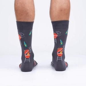 A pair of gray socks with a pattern of charcoal grills and beer bottles.