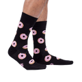 Lifestyle shot: Person wearing the Donut Stop Believing socks, showing how they look on feet.