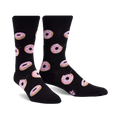 Pair of black crew socks with pink glazed donut pattern. Donuts have sprinkles and some are slightly 'bitten'.