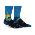 Pair of crew socks in blue, black, and green.  They feature a whimsical illustration of the Loch Ness Monster in a Scottish landscape.