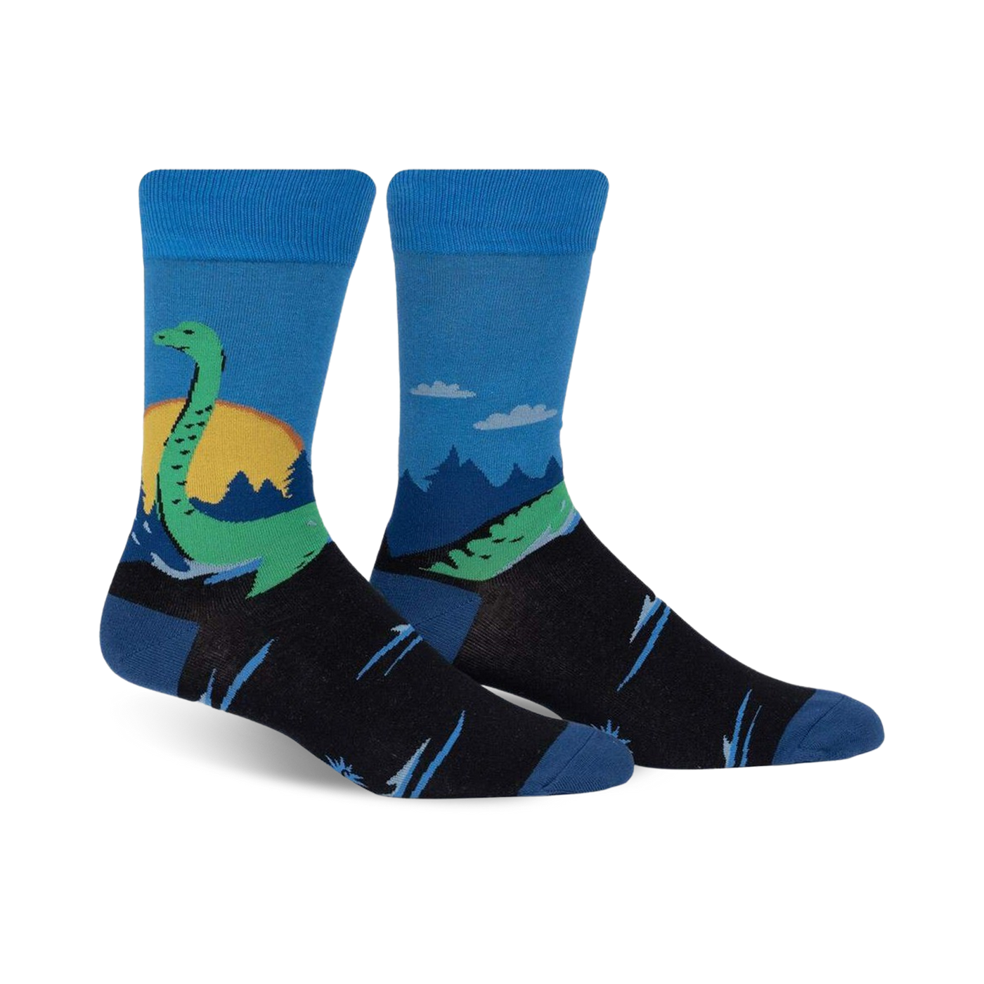 Pair of crew socks in blue, black, and green.  They feature a whimsical illustration of the Loch Ness Monster in a Scottish landscape.