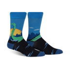 Pair of crew socks in blue, black, and green.  They feature a whimsical illustration of the Loch Ness Monster in a Scottish landscape.