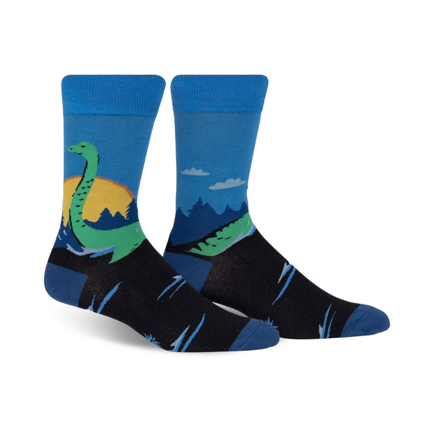 Pair of crew socks in blue, black, and green.  They feature a whimsical illustration of the Loch Ness Monster in a Scottish landscape.