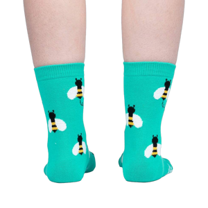 Back view of teal bee socks on a person's legs.