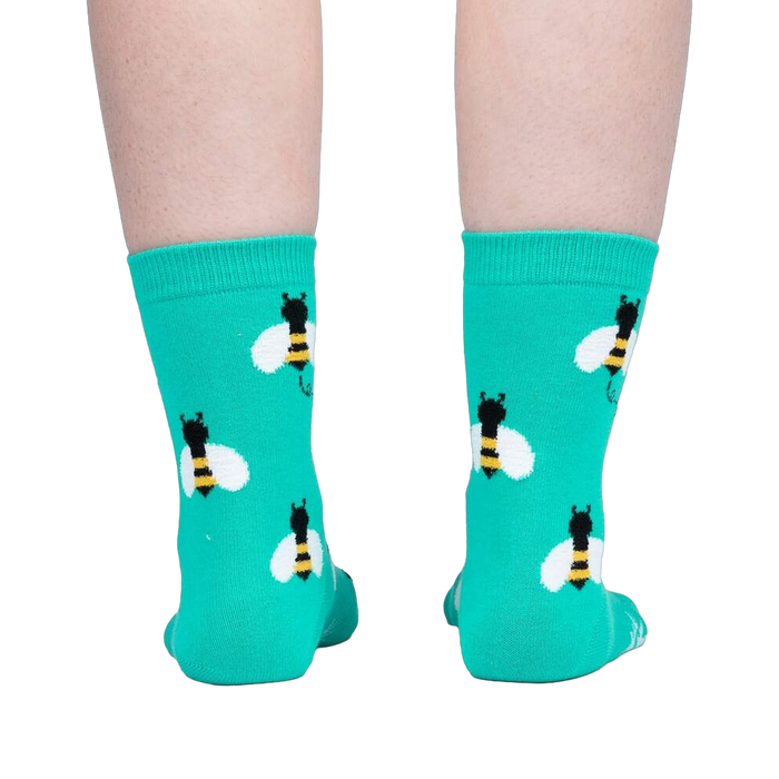 Back view of teal bee socks on a person's legs.
