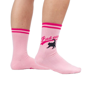 Lifestyle shot of a person wearing a pair of pink 'Bad Ass Cat' crew socks.