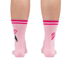 Rear view of a person's legs wearing pink 'Bad Ass Cat' socks, showing the full design on the back of the socks.