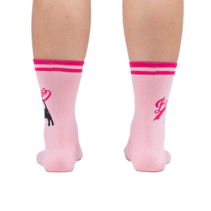 Rear view of a person's legs wearing pink 'Bad Ass Cat' socks, showing the full design on the back of the socks.