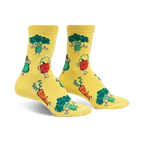Pair of yellow crew socks featuring cartoon broccoli, carrots, avocados, and apples exercising. 