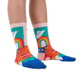 A person's legs wearing the Peace and Love socks.  Shows off the socks' vibrant colors and design in a lifestyle setting.