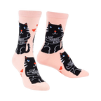 Crew socks in pale pink with a repeating pattern of black cats hugging themselves and the words 'Give Yourself A Hug'.
