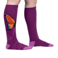 Flatlay: Two purple knee-high socks with an orange butterfly design are laid flat against a white background.