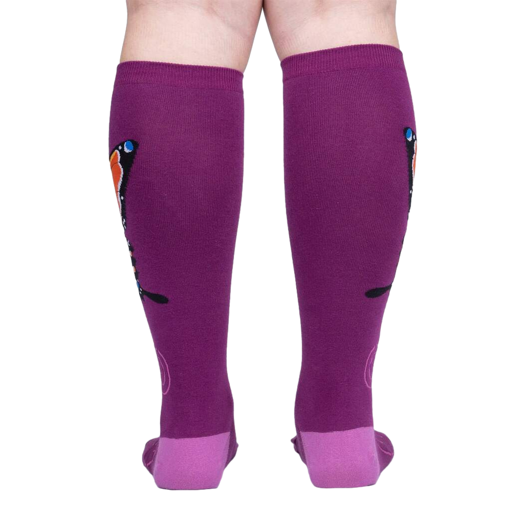 Back view of a person wearing purple knee-high socks with an orange butterfly design.