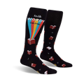 Pair of black knee-high socks with a whimsical design. Features red books, a rainbow, and the phrase 'Talk Wordy To Me'.