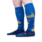 Lifestyle shot showing a person wearing the Aquatic Adventure socks. The socks are knee-high and feature a submarine design.