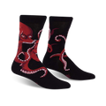 Pair of black crew socks with a red octopus reading a book; shown from the front.