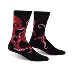 Pair of black crew socks with a red octopus reading a book; shown from the front.