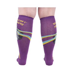 Rear view of a person wearing the purple 'Secret Powers' knee-high socks showcasing the design on the back of the socks.