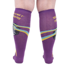 Rear view of a person wearing the purple 'Secret Powers' knee-high socks showcasing the design on the back of the socks.