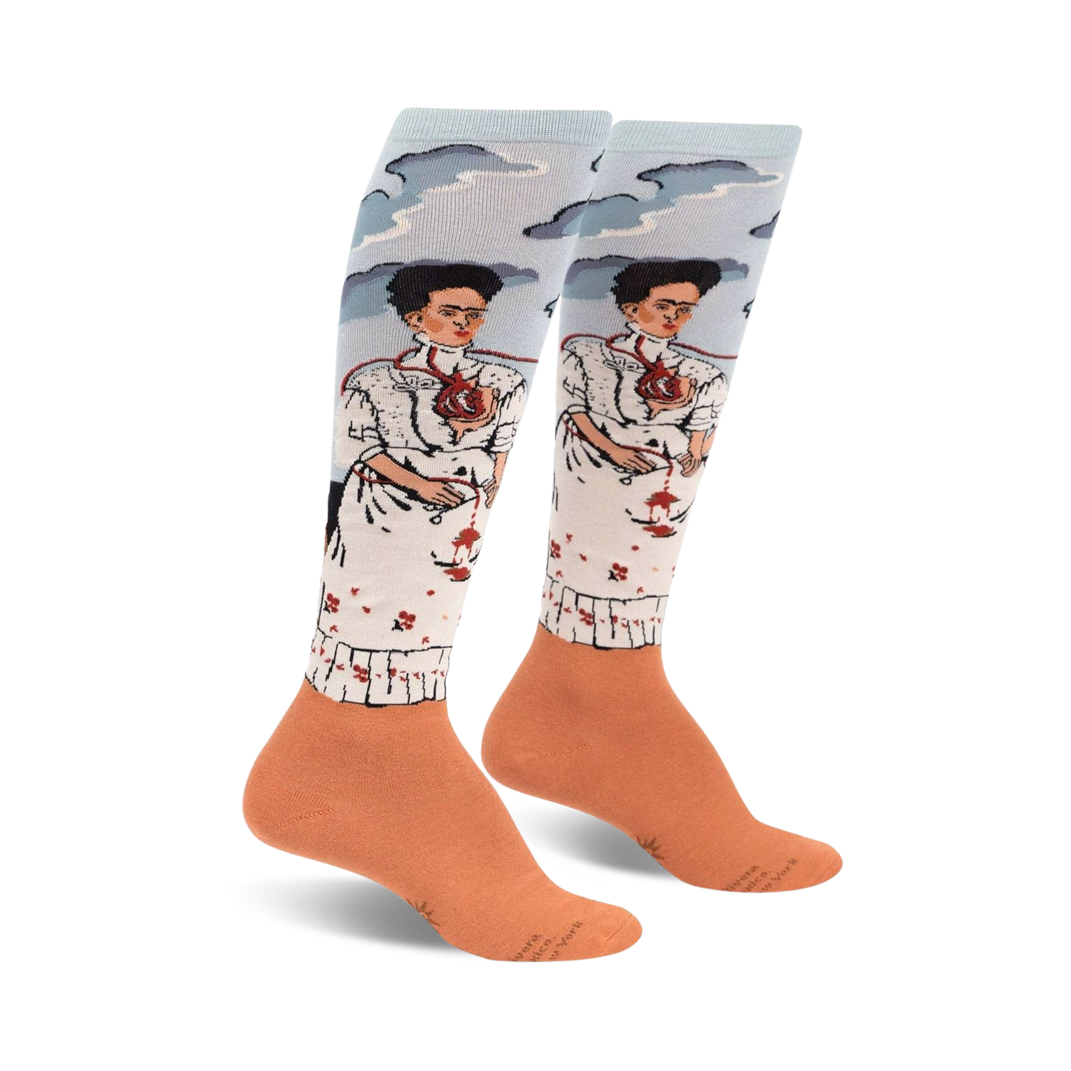 Pair of women's knee-high socks. Light blue background with two Frida Kahlo self-portraits, peach-colored cuffs.  Detailed artwork.