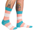 Lifestyle shot of Trans Pride socks on another person's legs, showing the socks from a different angle.