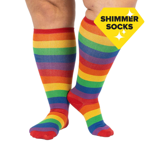 Lifestyle shot: A person's legs wearing the rainbow knee-high socks. The socks are the focus; the background is plain white.