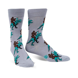 men's gray crew socks featuring bigfoot riding dinosaurs in black, brown, and teal.  