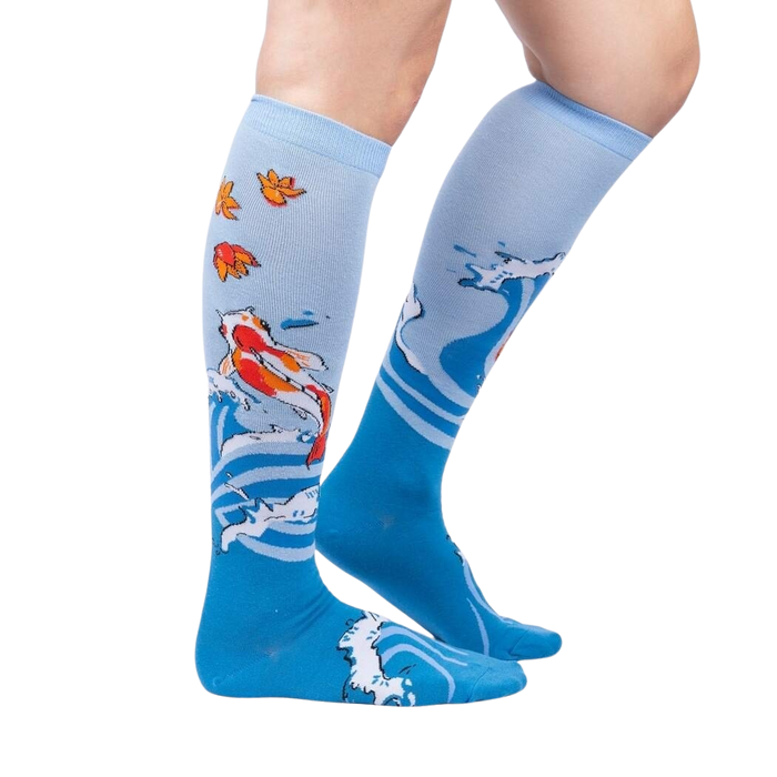 A pair of blue knee-high socks with a pattern of koi fish and maple leaves.