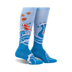 Pair of blue knee-high socks with a design of koi fish swimming in stylized waves and autumn leaves. 