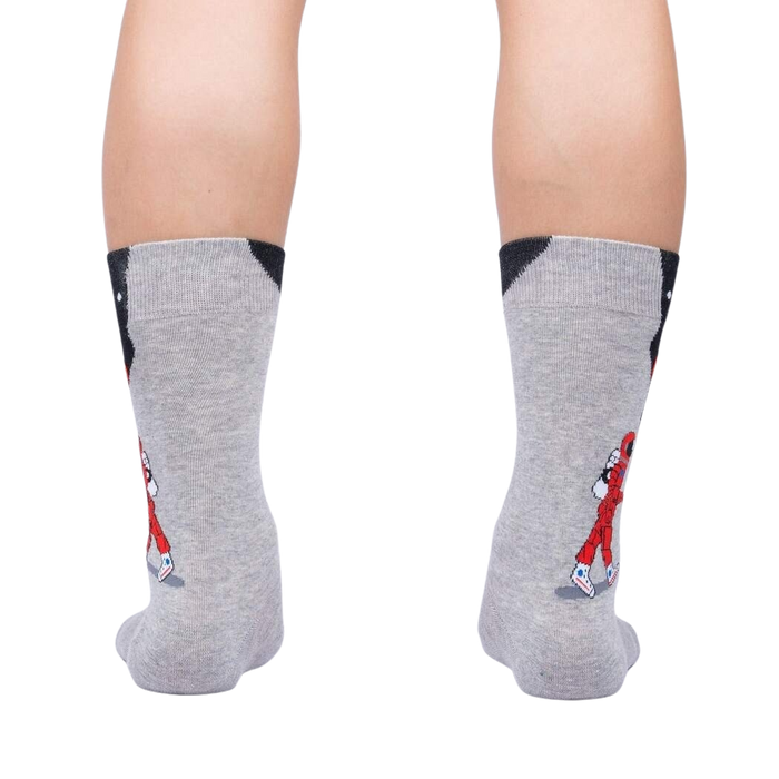 A pair of gray socks with an image of a golfer on each sock. The golfer is wearing a red shirt and white pants.