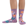Lifestyle shot showing the pufferfish socks on a person's feet. The socks are crew length and feature a fun design.