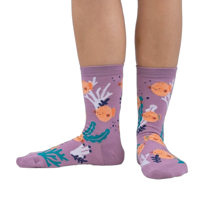 Lifestyle shot showing the pufferfish socks on a person's feet. The socks are crew length and feature a fun design.