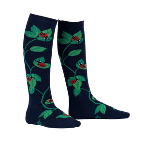 Close-up of 'Luck Be a Lady Bug' socks on a person's legs, showcasing the design and fit.